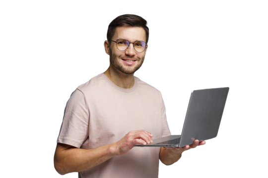 Young man with laptop smiling while standing in a bright indoor location with minimalistic design