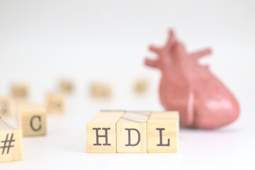 High-density lipoprotein acronym. HDL written on wooden cubes isolated with a heart on white background. Concept of cholesterol 