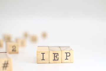 Individualized Education Program abbreviation. IEP acronym written on wooden cubes isolated on white background with space for text.