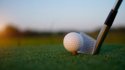 Golf clubs and balls on a green lawn in a beautiful golf course with morning sunshine.