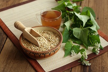 Herbal tea made from buckwheat seed, lat. Fagopyrum esculentum, fresh flowering plant next to it....