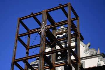 Steel scaffolding with a poinsettia on an old wall of a listed building