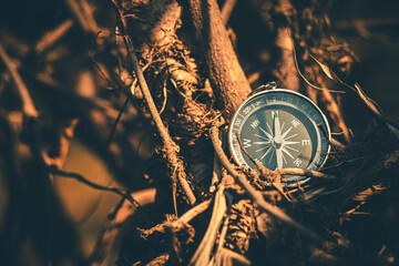 Weathered compass rests on a sandy landscape, marking an adventurous journey.