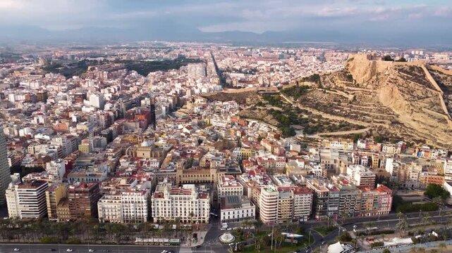 Historic city center of Alicante, perspective from Above. Famous travel destination in Spain. View of Castle of Santa B&aacute;rbara on top of the hill. Sunset point with orange and pink reflections. 