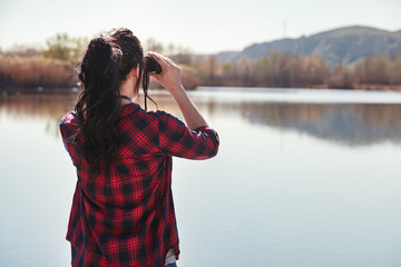 Reflection of hills in the lagoon at sunset with a young woman nearby