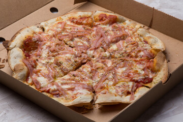 Pizza na caixa de papelão com queijo mozarela e vários sabores e condimentos, feita de massa fina, farinha