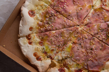 Pizza na caixa de papel&atilde;o com queijo mozarela e v&aacute;rios sabores e condimentos, feita de massa fina, farinha