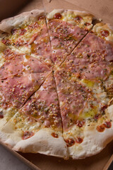 Pizza na caixa de papel&atilde;o com queijo mozarela e v&aacute;rios sabores e condimentos, feita de massa fina, farinha