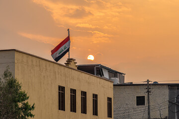 Sunset in Basra, Iraqi flag on a building.