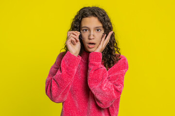 Oh my God, Wow. Excited amazed girl taking off eyeglasses in surprise looking at camera with big eyes blinking shocked by victory celebrating success achievement good news. Child on yellow background