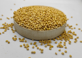 Millet seeds in a bowl on a white background, subject photography.