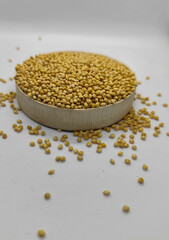 Millet seeds in a bowl on a white background, subject photography.