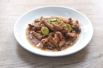 spicy stir fried slice pork with stink bean and chili in shrimp paste sauce on plate 