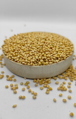 Millet seeds in a bowl on a white background, subject photography.