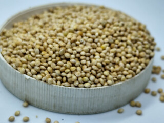 Millet seeds in a bowl on a white background, subject photography.