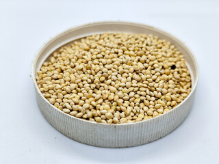 Millet seeds in a bowl on a white background, subject photography.