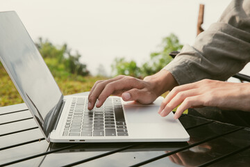 Young business man working computer on peak hill. Hiker online shopping on laptop at sunset, sunrise on top mountain, freelance person remote work with digital tablet. travel vacation holiday concept