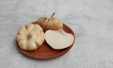 Fresh Jicama or bengkoang, white tubers that can be eaten as salad or for face masks. Isolated on grey background. Prebiotic food, gut health.