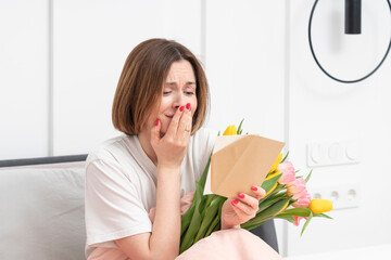 A young beautiful girl received a bouquet of flowers and a congratulatory letter on a wonderful...