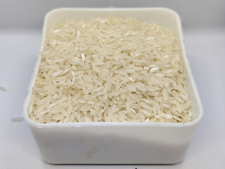 Unprocessed rice, on a natural blurred white background.