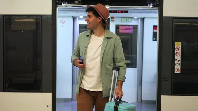 Happy traveler getting off train with suitcase and smartphone at vacation destination, 4k video