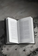 Fototapeta premium A large open book lying flat on the ground with a black and white page exposed, white, flat, large