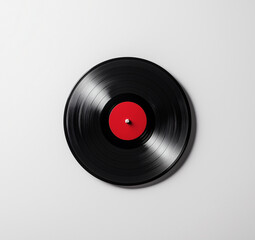 Fototapeta premium black vinyl record with striking red label, set against clean white background, evokes sense of nostalgia and classic music vibes