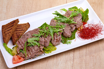fried beef with salad and sauce