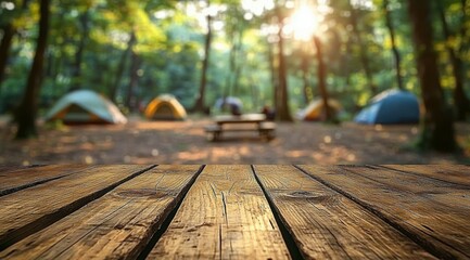 Fototapeta premium Rustic wooden table in the foreground and blurred forest campsite in the background create a summer outdoor scene for product display or advertising design montage template