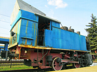 A rusty old steam locomotive in a field