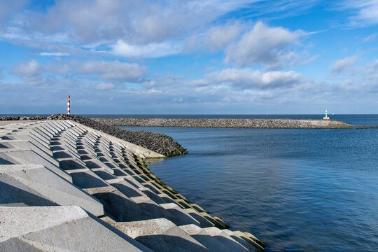 Port of escape on former Breezand working island on Afsluitdijk (dam separates IJsselmeer lake from Wadden Sea), the Netherlands  against a white clouded blue sky