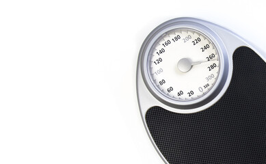 Analog weight scale with a black platform and silver frame, placed against a white background