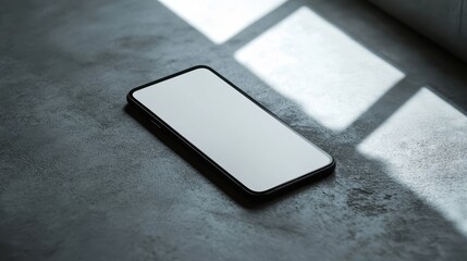 Blank mockup template of a sleek smartphone resting on a smooth gray surface, with soft lighting and minimalistic design.