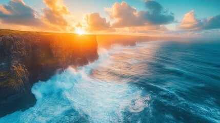 Obraz premium Majestic cliffs meet the turbulent ocean at sunset, the sky ablaze with warm hues of orange and blue, waves crashing dramatically against the rugged shoreline.