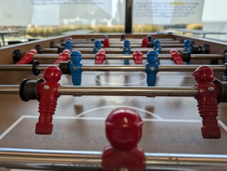 A close portrait of a fussball table at the level of the minature plastic football or soccer players in a bar or café. they are ready to be played with.