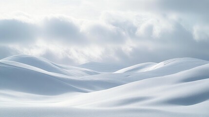 A wide-open winter landscape with rolling hills covered in snow and a cloudy sky.