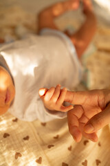 a baby laying on a bed with a toy in his hand