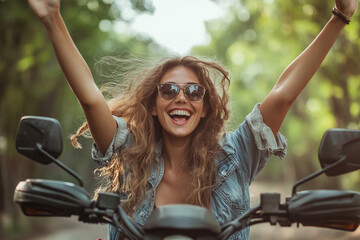 Joyful young woman on a four-wheeler, arms raised, enjoying a forest ride