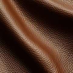 Close-up of brown leather texture with subtle folds and lighting variations.