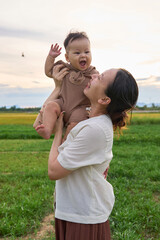 there is a woman holding a baby in her arms in a field