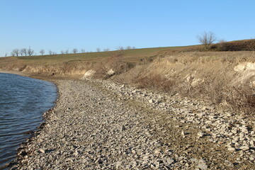 A river running through a dry grassy field
