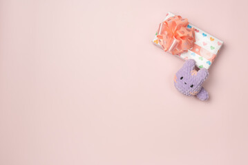 Gift box with toy on pink background . Flat lay, top view. Copy space