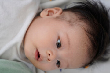 a close up of a baby laying on a bed