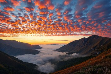  Sunrise over mountains with clouds and fog in the valley below