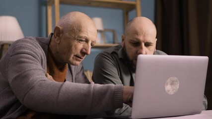 Son teaching father to use laptop and technology