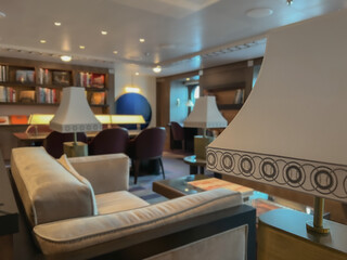Cozy living room atmosphere inside cafe café coffee shop bar lounge bistro onboard luxury cruiseship cruise ship liner in contemporary Art Deco interior design