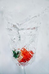
A crystal-clear glass captures the energy of a splash, highlighting a vibrant red strawberry and green mint leaves. The frozen motion and clean background create a striki