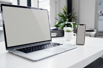 Laptop and smartphone mockup on a clean white desk with blurred office background.