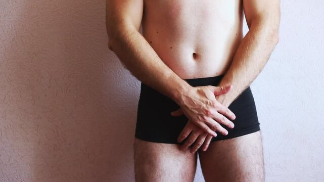 Guy in black underpants and bare torso massaging himself. Men's health.