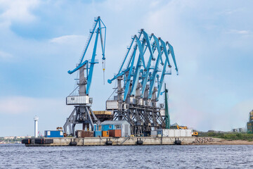 Fototapeta premium Multi gantry crane blue color view from the river to the port